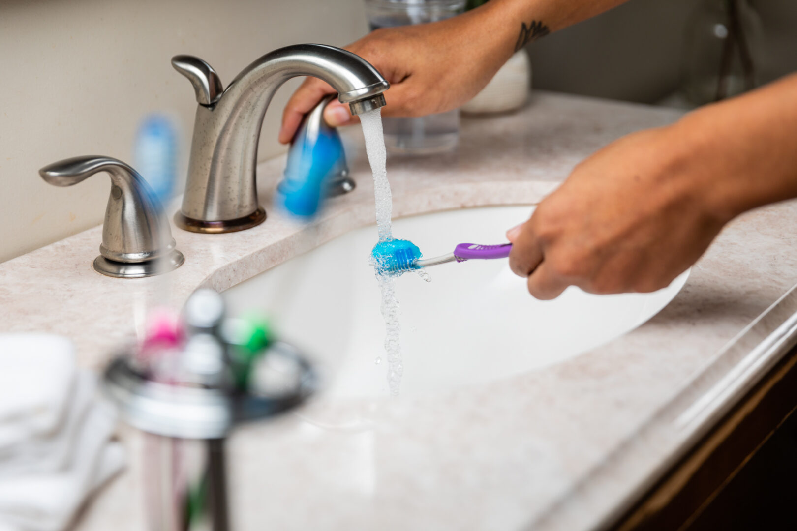 A person is washing their hands with toothpaste and brush.