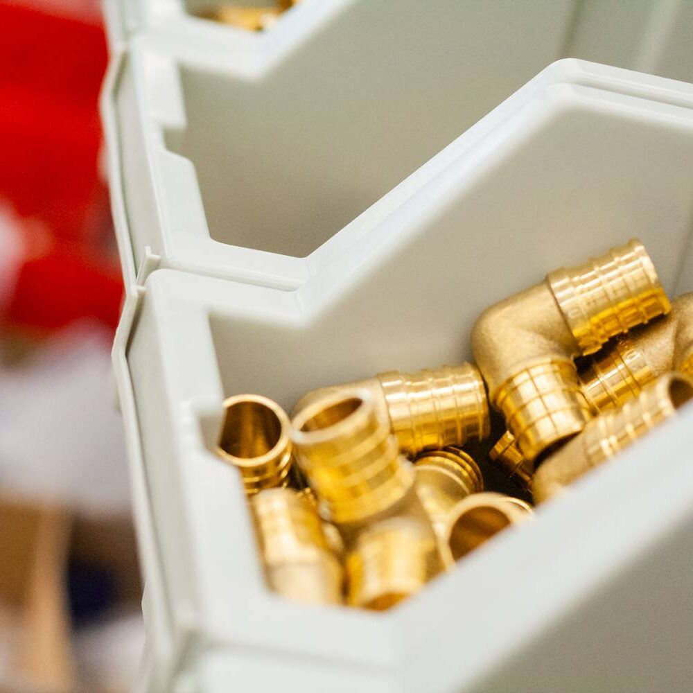 A close up of some brass fittings in a bin